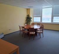 Zasedací místnost s kulatým stolem a židlemi v kanceláři.