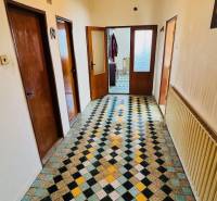 Chodba v rodinném domě s barevným geometrickým vzorem na podlaze.