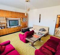 Obývací pokoj v rodinném domě s retro nábytkem a barevnými křesly.