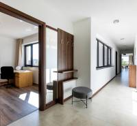 Světlá chodba s pracovnou místností a podlahou s dřevěným dekorem ve 3-pokojovém bytě.