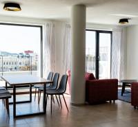 Obývací pokoj ve 3-pokojovém bytě s jídelním stolem a výhledem na město.