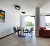 Jídelna ve 3-pokojovém bytě s obrazem slunečnic, podlahou s dřevěným dekorem, výhledem na terasu.