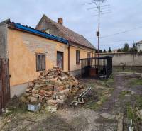 Rodinný dům ve Dvorech nad Žitavou s hromadou cihel a starou fasádou.