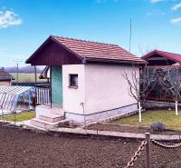 Chata v Partizánskych s upravenou zahradou, skleníkem a pěstitelskou plochou.