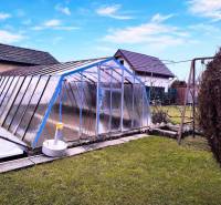 Zahrada v Partizánském s nadzemním bazénem zakrytým konstrukcí, houpačka, zelený trávník.