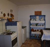 Kuchyně v rodinném domě s tradičním nábytkem a dekoracemi, podlaha s dřevěným dekorem.