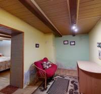 Pokoj v rodinném domě s podlahou s dřevěným dekorem, pohovkou a malým stolem.