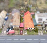 Rodinný dům na Hlavní ulici v Hronském Beňadiku s červenou střechou a zahradou.