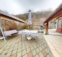 Balkón rodinného domu na Hlavní ulici v Hronském Beňadiku s houpačkou a stolem.