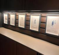 Zarámované obrázky na dřevěné poličkové stěně v 2-pokojovém bytě.