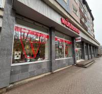 Obchodní prostory v Popradu s výrazným červeným logem na budově.