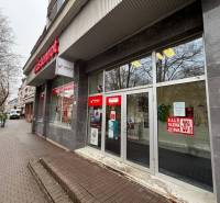 Obchodní prostory v Popradu s velkými skleněnými výlohami, obsahují reklamu na slevy.