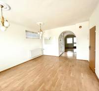 Interiér rodinného domu s podlahou s dřevěným dekorem a zdobeným osvětlením.