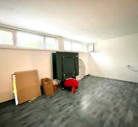 Pokoj v rodinném domě s podlahou s dřevěným dekorem, okny a kartonovými krabicemi.