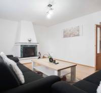 Obývací pokoj ve 4pokojovém bytě s krbem a podlahou s dřevěným dekorem.