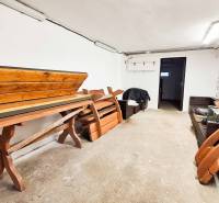 V 4-pokojovém bytě se nachází místnost s dřevěným nábytkem a bílými stěnami.