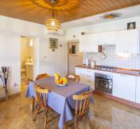 Kuchyně v rekreačním apartmánu s podlahou s dřevěným dekorem a jídelním koutem.