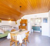 Rekreační apartmán s podlahou s dřevěným dekorem, jídelním stolem a kuchyní.