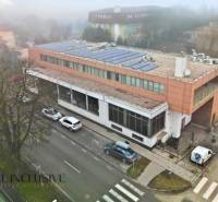 Obchodní prostory v Topoľníkoch se solární střechou, cestou a parkovištěm.