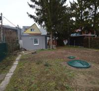 Zahradní chatka v Bratislavě - Ružinov, Studená ulice, obklopená stromy a oplocením.