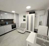 Kuchyně v chatě, s jídelním stolem a šedými kuchyňskými skříňkami.