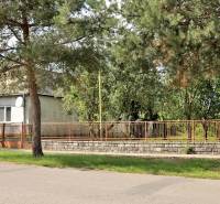 Dům obklopený stromy v Lastomíre, pozemky - bydlení, oplocení s bránou.