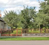 Rodinný dům a pozemek pro bydlení v Lastomíru s oplocením a okolní zelení.