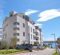 Budova rekreačního apartmánu ve městě Pag, blízko moře. Parkoviště u stavby.