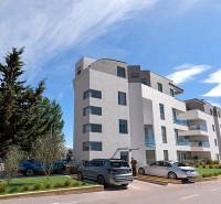 Rekreační apartmán ve městě Pag s moderní budovou a parkovištěm.