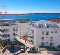 Výhled na mořskou zátoku s Rekreačním apartmánem ve městě Pag, moderní architektura u pobřeží.