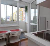 Kuchyně v 1-pokojovém bytě s výhledem a balkonem, podlaha s dřevěným dekorem.