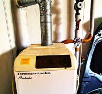 Plynový kotel Termogas 25 eko s připojenými potrubími v rodinném domě.