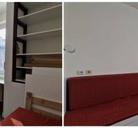 V rodinném domě jsou bílé skříňky, pracovní stůl a červená sedačka.