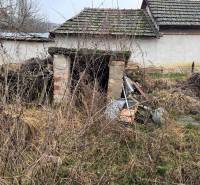 Opuštěná budova na pozemku v Dubníku s neudržovaným okolím a starými střechami.