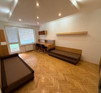 Obývací pokoj v 3-pokojovém bytě s podlahou s dřevěným dekorem a pracovním stolem.