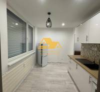 Kuchyně v 1-pokojovém bytě s podlahou s dřevěným dekorem a moderním osvětlením.