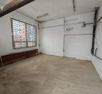 Interiér garáží s oknem a mříží, podlaha s dřevěným dekorem.