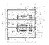 Architektonický půdorys vícepodlažní budovy zobrazující rozložení místností a schodiště.