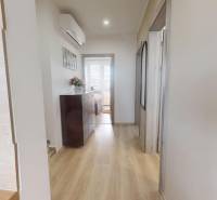 Chodba v 3-pokojovém bytě s podlahou s dřevěným dekorem, komodou a klimatizací.