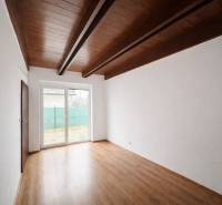 Pokoj v rodinném domě s podlahou s dřevěným dekorem a velkým oknem.