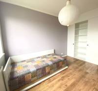 Dětský pokoj v 3pokojovém bytě s postelí a podlahou s dřevěným dekorem.