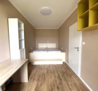 Pokoj ve 3-pokojovém bytě s podlahou s dřevěným dekorem a vestavěným stolem.