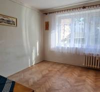 Pokoj s oknem a podlahou s dřevěným dekorem ve 3-pokojovém bytě.