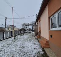 Rodinný dům na ulici Nová ve Velkých Ozorovcích se zasněženým dvorem a plotem.