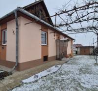 Rodinný dům na Nové ulici ve Velkých Ozorovcích s trubkovým altánkem a zasněženou zahradou.