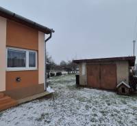 Rodinný dům na Nové ulici ve Velkých Ozorovcích se zasněženou zahradou a garáží.