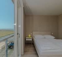 Ložnice v rekreačním apartmánu s výhledem, postelí a podlahou s dřevěným dekorem.