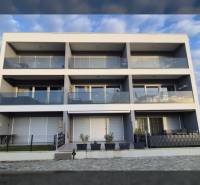 Třípodlažní rekreační apartmán ve městě Vrsi, na ulici Zukve s balkony a prosklenými zábradlími.