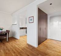 Interiér 2-pokojového bytu s jídelnou, kuchyní a vstupem, podlaha s dřevěným dekorem.