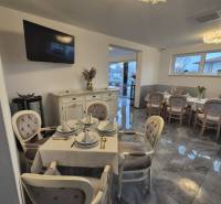 Hedvábná dekorace Gastro prostory s jídelním koutem, podlaha s dřevěným dekorem, jemné osvětlení.